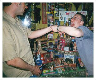 Pup Striker Nigel Hoyland is very taken with some of the local handicrafts, after Brown demonstrates how they are used. [Photo:S.Loriot]